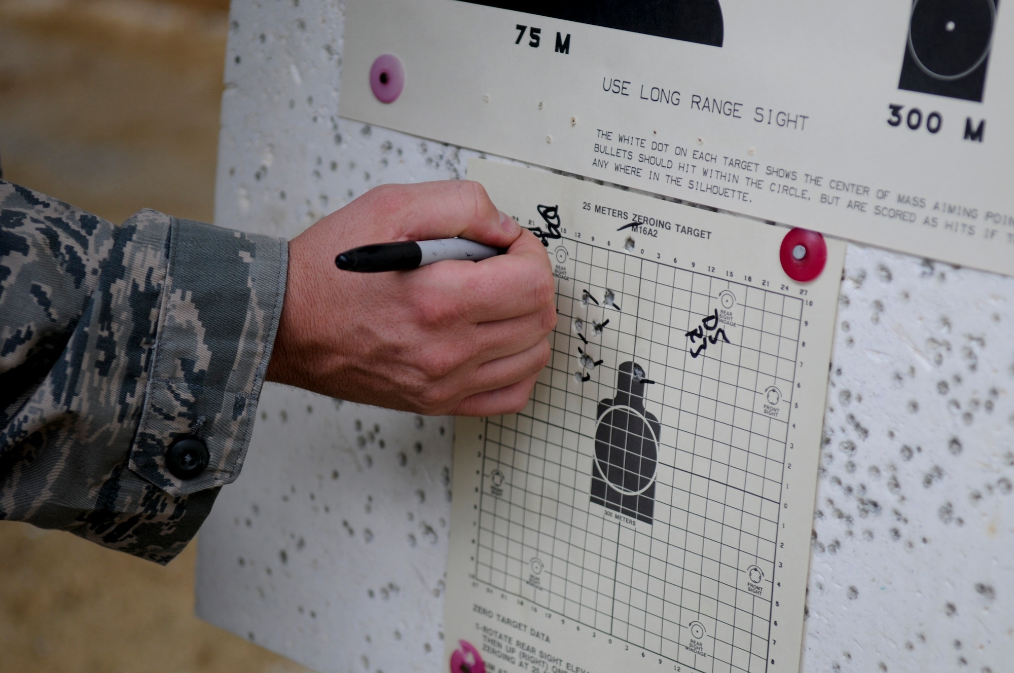 An 18th Security Forces Squadron Combat Arms instructor indicates a qualifying Airman's sight corrections on a zeroing target at Kadena's newly-refurbished firing range May 24. Though only about 75 percent complete with renovations, roughly 100 soon-to-deploy Airmen are now passing through the range each week to qualify on their appropriate weapons. (U.S. Air Force photo/ Airman 1st Class Maeson L. Elleman)