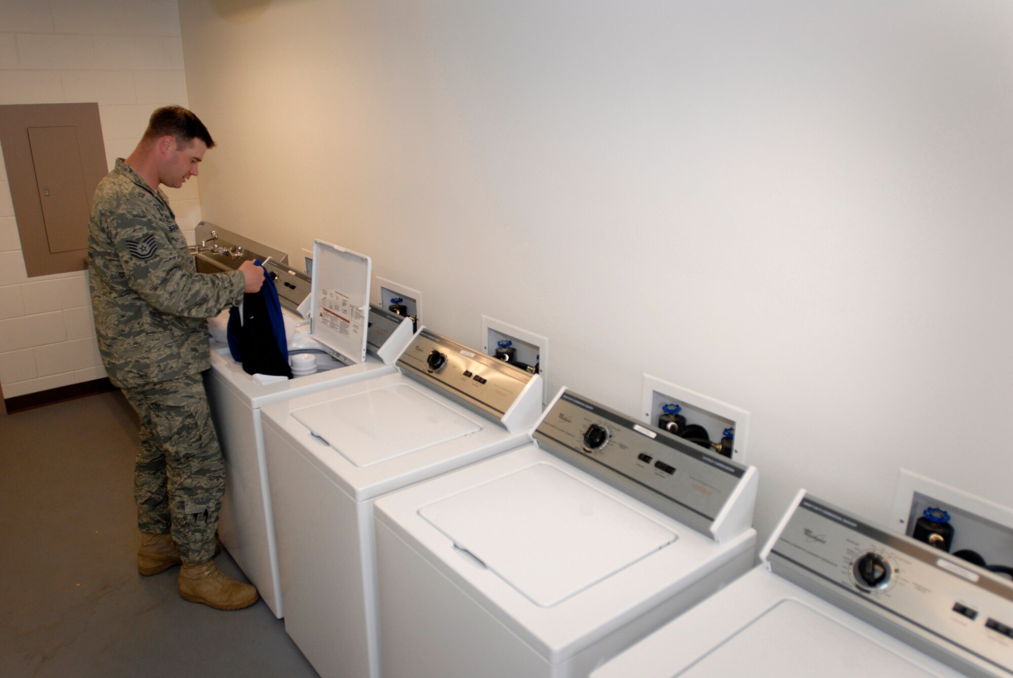 Tech. Sgt. Timothy Stolicker, an electrician assigned to the 51st Civil Engineer Squadron, Osan Air Base, Republic of Korea, uses a new washing machine in building 718. New washing machines were included as part of the recently completed renovations to buildings 717 and 718. (U.S. Air Force photo)