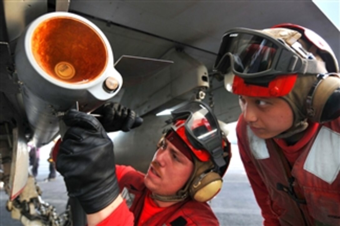 U.S. Navy Seaman Korey Chavis (left) installs wing and fin attachments to an AIM-120 AMRAAM missile while Seaman John Chang (right) observes aboard the aircraft carrier USS Ronald Reagan (CVN 76) underway in the Arabian Gulf on May 20, 2011.  