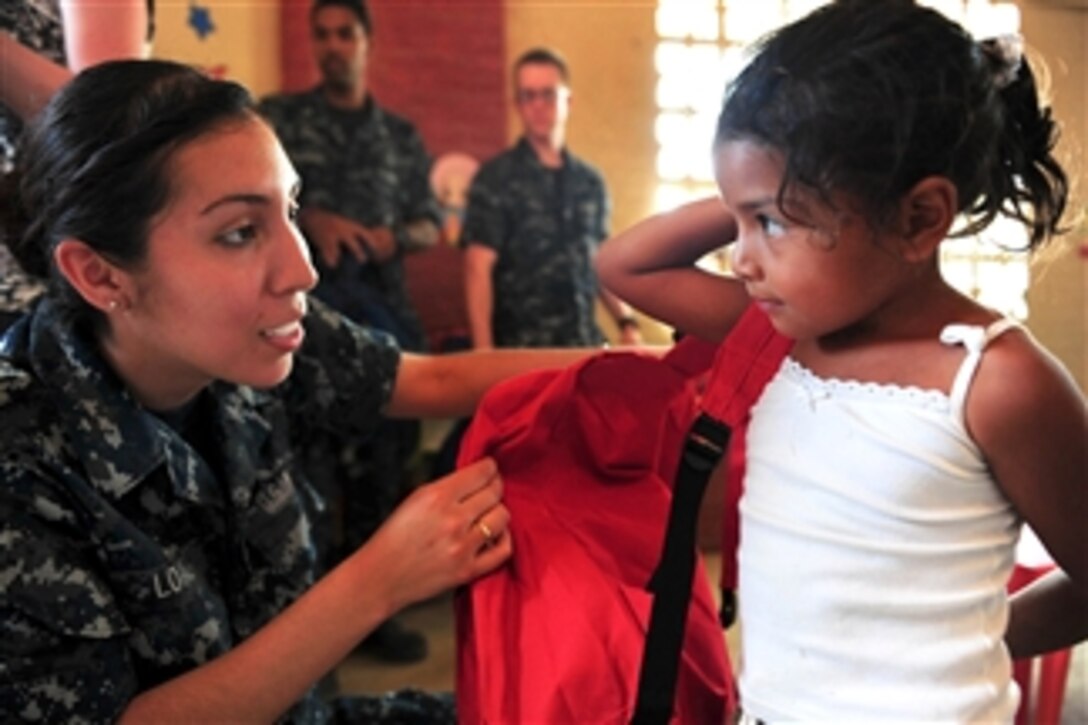 U.S. Navy Seaman Arianna Loaiza helps a student put on a donated backpack during a Continuing Promise 2011 community service event in Santa Rosa, Ecuador, on May 20, 2011.  