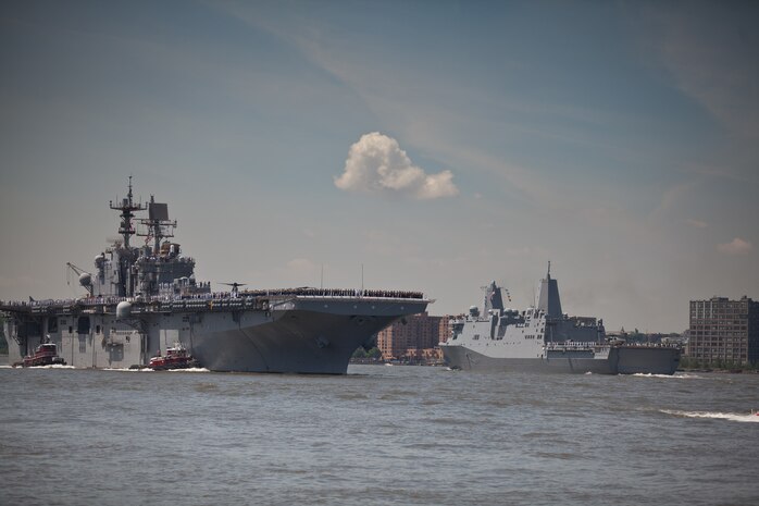 Marines from the 24th Marine Expeditionary Unit and sailors stand on the deck of USS Iwo Jima as it sails past USS New York to Pier 88 during Fleet Week 2011 parade of ships, May 25. USS New York was built using salvaged steel from Ground Zero. More than 3000 Marines, sailors and Coast Guardsmen will participate in community events and military demonstrations throughout the city. Fleet Week 2011 begins May 25 and continues through June 1.
