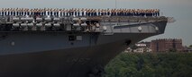 Marines from the 24th Marine Expeditionary Unit and sailors salute New York from the deck of USS Iwo Jima as it prepares to dock at Pier 88 during Fleet Week 2011 parade of ships, May 25. More than 3000 Marines, sailors and Coast Guardsmen will participate in community events and military demonstrations throughout the city. Fleet Week 2011 begins May 25 and continues through June 1.