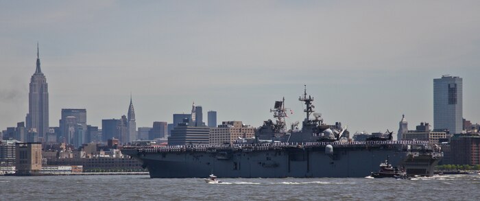 Marines from the 24th Marine Expeditionary Unit and sailors salute New York from the deck of USS Iwo Jima as it sails to Pier 88 during Fleet Week 2011 parade of ships. More than 3,000 Marines, Sailors and Coast Guardsmen will be in the area participating in community outreach events and equipment demonstrations. This is the 27th year New York has hosted the sea services for Fleet Week.