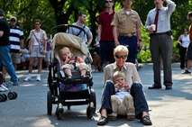 Silke Kluever, 42, from New York City, and her children, Julian, 3, and Lucas, 1, listen to the Parris Island Marine Band announce the arrival of Marines to New York City as they perform  in the Central Park Band Shell, New York City, May 25. More than 3000 Marines, sailors and Coast Guardsmen will participate in community events and military demonstrations throughout the city. Fleet Week 2011 begins May 25 and continues through June 1.