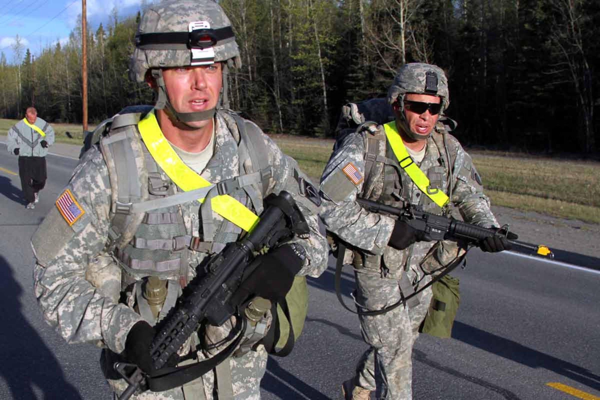 Pfc. Jason Woolard, 6th Engineer Battalion (Combat) (Airborne), and Spc. Ronald Burton, 725th Brigade Support Battalion (Airborne), cross the four-mile marker during a 12-mile road march, May 20, part of the test for the Expert Field Medical Badge. (U.S. Army photo/Staff Sgt. Jason Epperson)