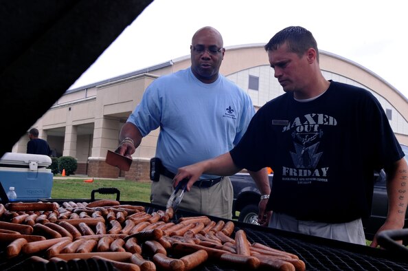 BARKSDALE AIR FORCE BASE, La. - Tech. Sgt. Tommy Labarron (right) and Robert Sedberry, both from the 2nd Force Support Squadron, grill hotdogs during Sports Day at the fitness center on Barksdale Air Force Base, La., May 25. More than 1,000 hot dogs were donated for the event. Sports Day was designed to improve teamwork and promote the Air Force's Fit-to-Fight mission. (U.S. Air Force photo by Senior Airman La'Shanette V. Garrett)