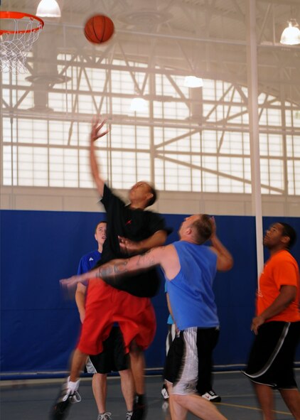 Airmen of the 608th Air Operations Center and the 2nd Communications Squadron, go up for the basketball in a 3-on-3 tournament during Sports Day at the fitness center on Barksdale Air Force Base, La., May 25.  Each game had a 10-minute time limit and the first team to reach 15 won. (U.S. Air Force Photo/Senior Airman La'Shanette V. Garrett) (RELEASED) 