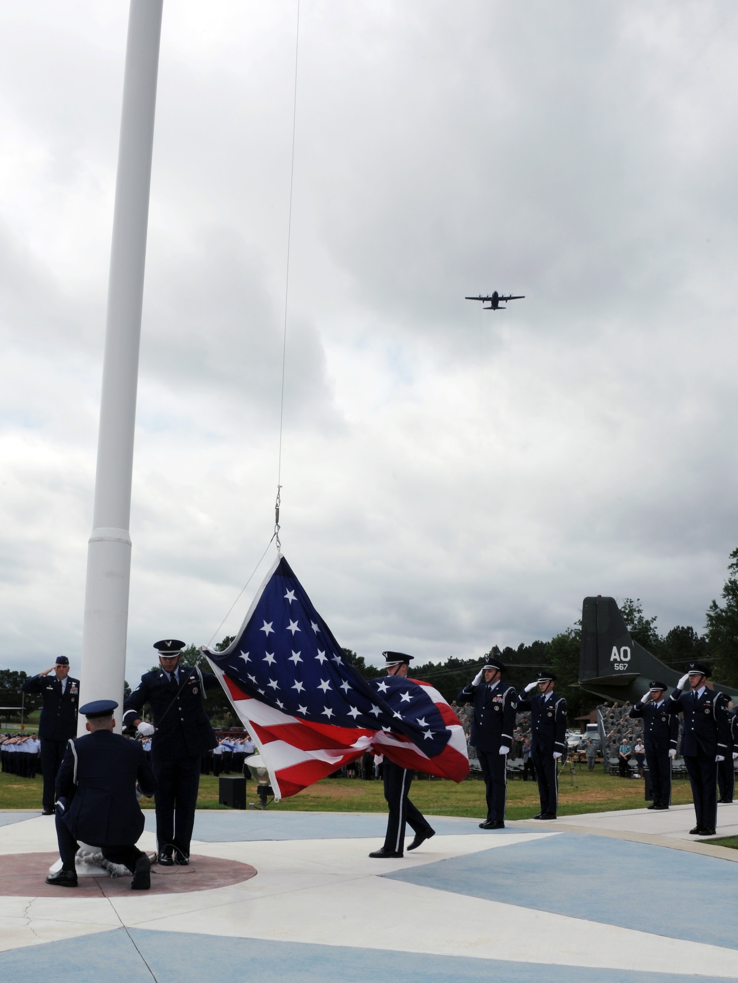 A C-130 flies over Heritage Park as members of the base honor guard retrieve the American flag during a Memorial Day retreat ceremony May 26, 2011, at Little Rock Air Force Base, Ark. The ceremony was a chance for Airmen and community members to honor the servicemembers who have fallen through the years.  (U.S. Air Force photo /Airman 1st Class Rusty Frank)