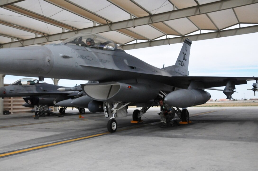 Staff Sgt. Justin Foulsham, Crew Chief; 113 AMXS, conducts pre-flight checks on an F-16 prior to exercises during Green Flag West at Nellis AFB, Nev., May 22, 2011. Green Flag West replicates irregular warfare conditions currently found in Southwest Asia. Aircrews, work closely with Air Force joint terminal attack controllers. Pilots train for a mission such as close air support, and aerial reconnaissance.  (U.S. Air Force photo by Tech. Sgt. Tyrell Heaton/Released)