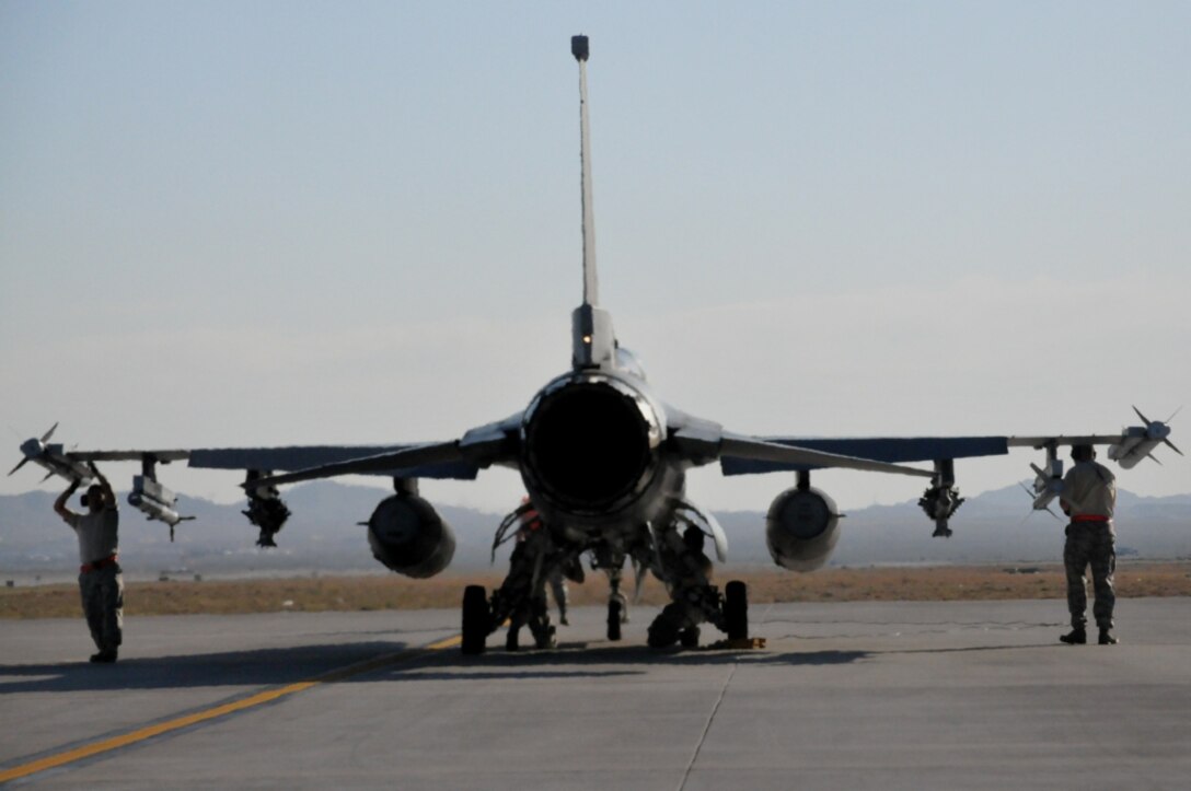 Weapons loaders from the 113 conduct pre-flight armament procedures on an F-16 during Green Flag West at Nellis AFB, Nev., May 23, 2011. Green Flag West replicates irregular warfare conditions currently found in Southwest Asia. Aircrews, work closely with Air Force joint terminal attack controllers. Pilots train for a mission such as close air support, and aerial reconnaissance.  (U.S. Air Force photo by Tech. Sgt. Tyrell Heaton/Released)