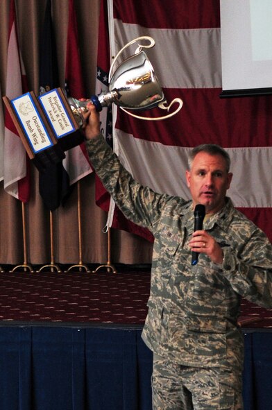 Col. Tim Fay, 2nd Bomb Wing commander, hoists the Brig. Gen. Fredrick W. Castle Award for Outstanding Bomb Wing into the air for all 2 BW Airmen to see during a Safety Day brief at Hoban Hall, May 26. Colonel Fay expressed his gratitude to the Airmen for their hard work by displaying the trophy before beginning the safety brief, which covered summer safety tips prior to the start of the Memorial Day weekend and the 101 Critical Days of Summer. (U.S. Air Force photo/Senior Airman Joanna M. Kresge)(RELEASED)