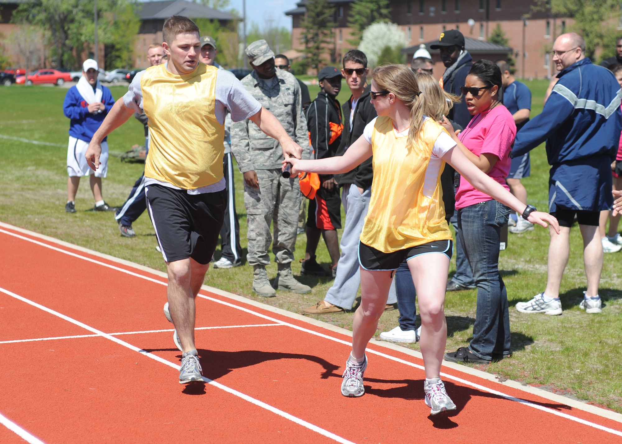 Tech. Sgt. Jason Gall, 319th Air Base Wing, passes the baton off to Capt. Valerie Nolan, 319th ABW, during the 1600 meter relay May 25 during the base’s annual Spring Fest competitions. (U.S. Air Force photo by Staff Sgt. Suellyn Nuckolls)