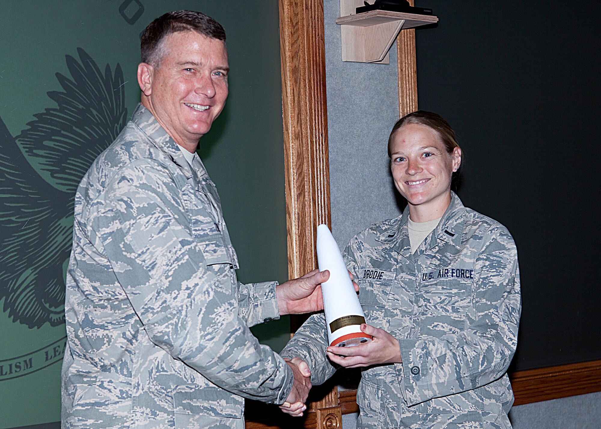 Col. Greg Tims, 90th Missile Wing commander, accepts the Nuclear Logisticians Award from 1st Lt. Christin Brodie, 90th Logistics Readiness Squadron, and the National Logistics Officers Association Wednesday. Lt. Col. Jondavid Duvall, 90th LRS, presented the award to Colonel Tims, bestowing upon him the honorary title of “Loggie.” (U.S. Air Force photo by Matt Bilden)