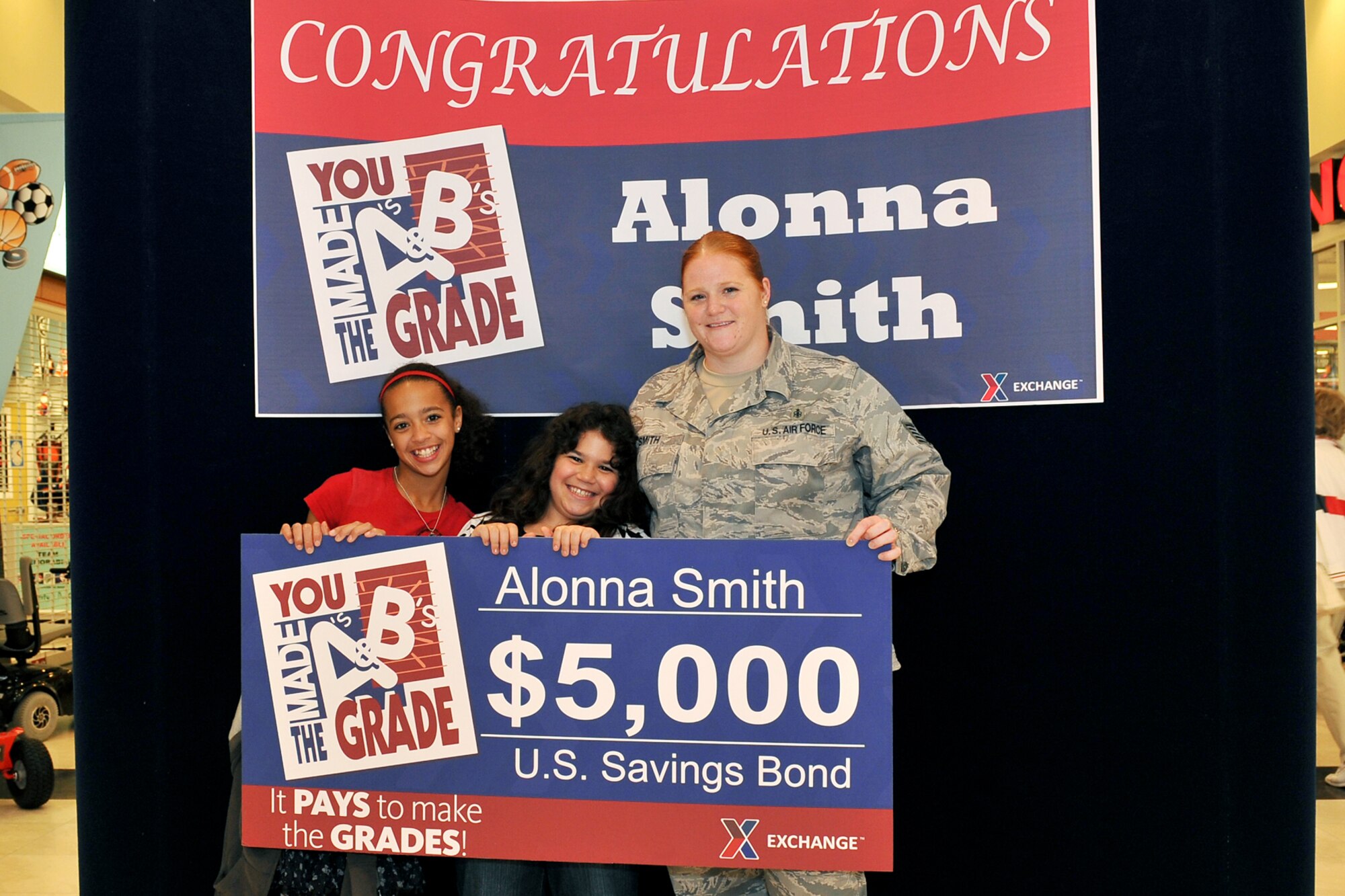 OFFUTT AIR FORCE BASE, Neb. - Offutt family member Alonna Smith, is joined by her mother Tech. Sgt.  Melissa Smith and her sister Jasmine Smith after being presented with a $5,000 savings bond for winning AAFES “You Made The Grade” competition. The presentation took place at the base exchange here May 25. U.S. Air Force photo by Charles Haymond 