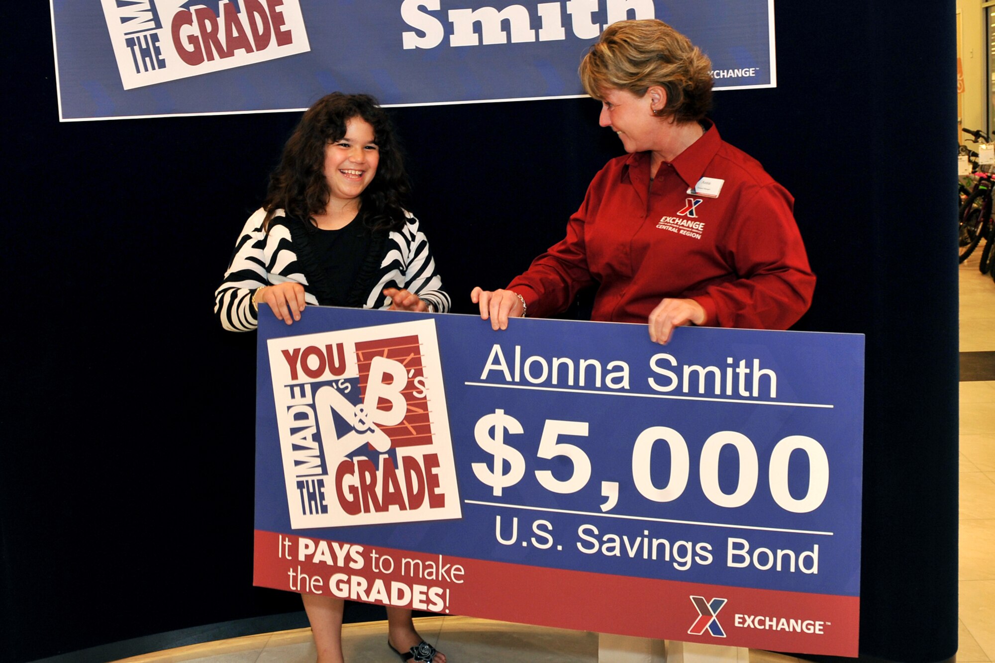 OFFUTT AIR FORCE BASE, Neb. - Offutt family member Alonna Smith, daughter of Tech. Sgt.  Melissa Smith from the 55th Medical Group, was presented with a $5,000 savings bond during a “You Made The Grade” presentation ceremony at the base exchange here May 25. The check was presented by Anna Stanton, the base exchange’s general manager. U.S. Air Force photo by Charles Haymond
