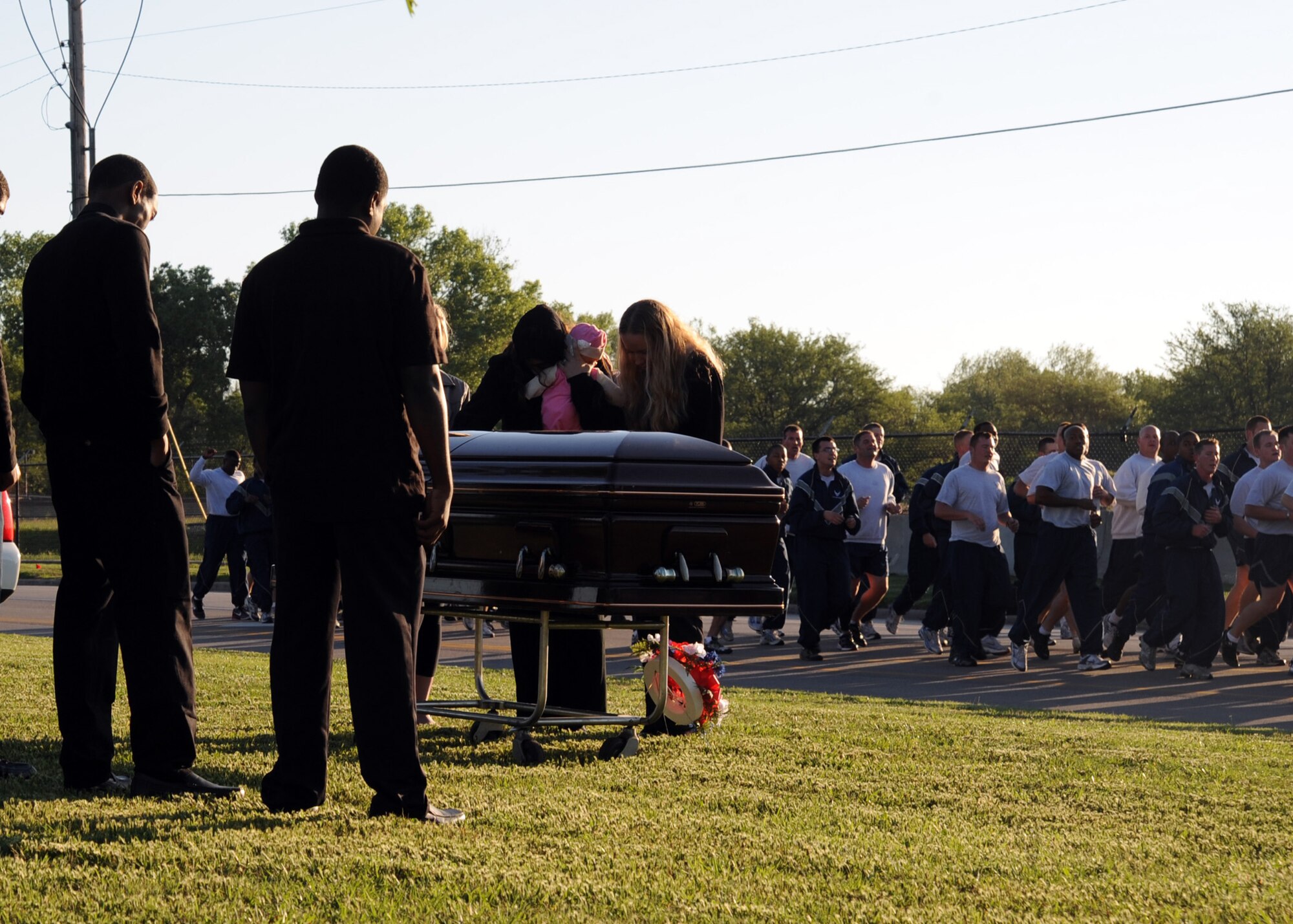 Members of the 22nd Air Refueling Wing run by a mock funeral during a wing formation run June 26, 2011, McConnell Air Force Base, Kan. The 22nd ARW safety office hosted the run and, setting up displays along the route to remind Airmen of the dangers of traffic accidents. The Critical Days of Summer campaign is May 27 to Sept. 6, 2011. The goal is to ensure all of Team McConnell has an injury free summer. (U.S. Air Force photo/Staff Sgt. Dallas Edwards)