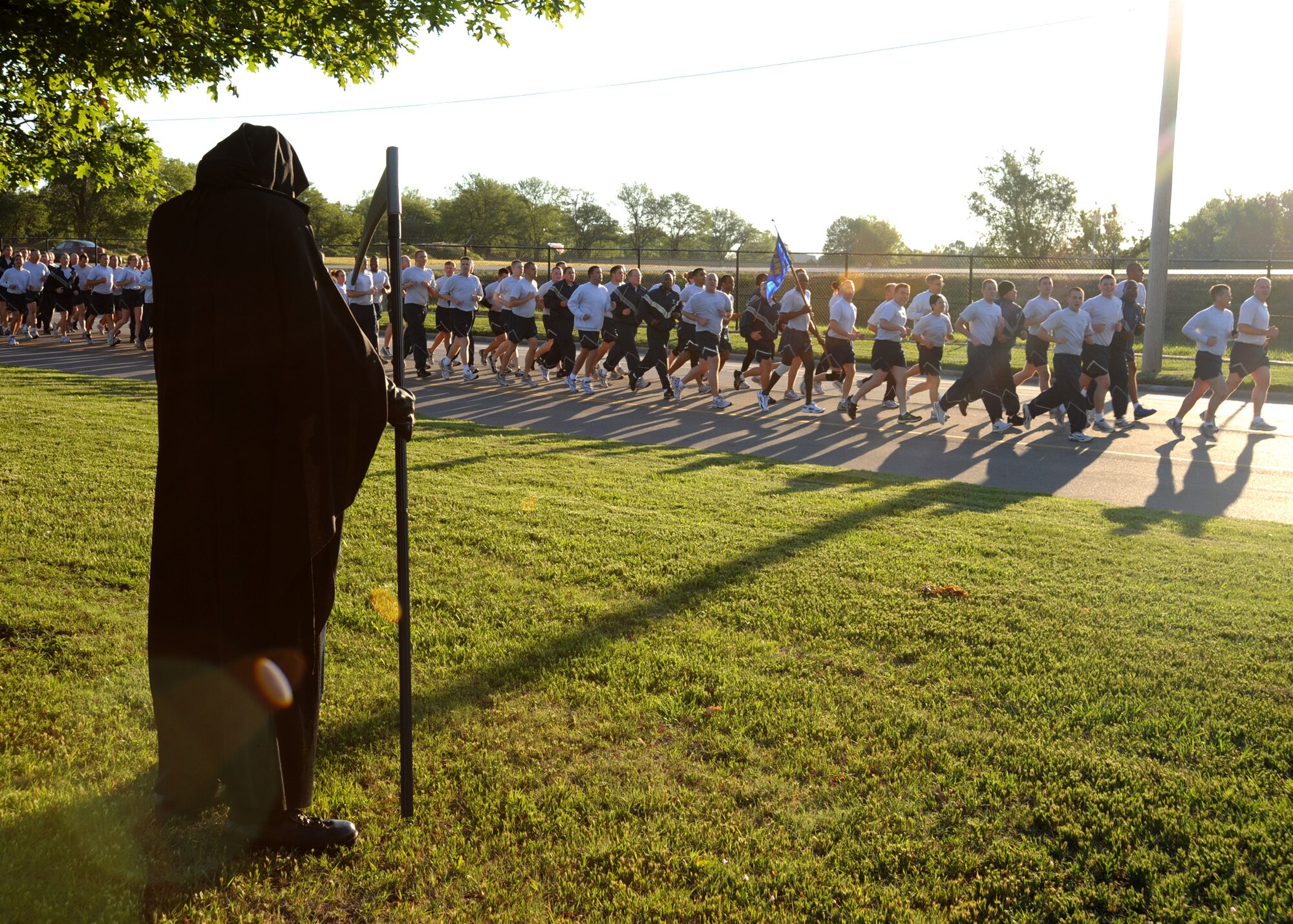 A McConnell member dressed as the Grim Reaper stands by the side of the road while members of the 22nd Air Refueling Wing participate in a wing run May 26, 2011, McConnell Air Force Base, Kan. The wing run marked the kick off for the 2011 Critical Days of Summer campaign, which will be held from May 27 to Sept. 6, 2011. The Grim Reaper was part of a mock accident scene and funeral addressing the importance of traffic safety.  (U.S. Air Force photo/Staff Sgt. Dallas Edwards)