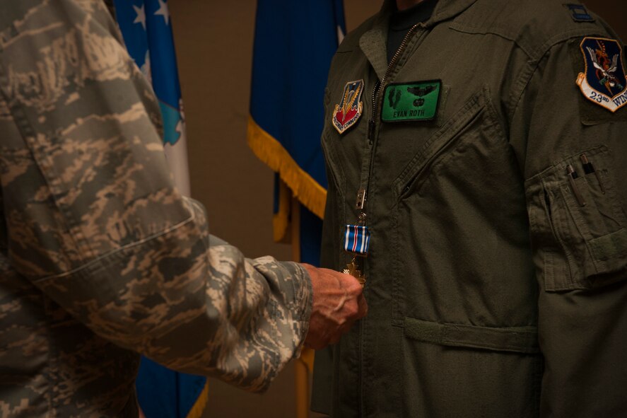 MOODY AIR FORCE BASE, Ga.-- Gen. William M. Fraser III, commander of Air Combat Command, places a Distinguished Flying Cross Medal on Capt. Evan Roth, 41st Rescue Squadron flight commander, during an award ceremony May 20. Captain Roth rescued a casualty and an injured soldier, flying them to the nearest medical facility and enabling the ground unit to complete their mission. (U.S. Air Force photo/Airman 1st Class Joshua Green)(RELEASED)
