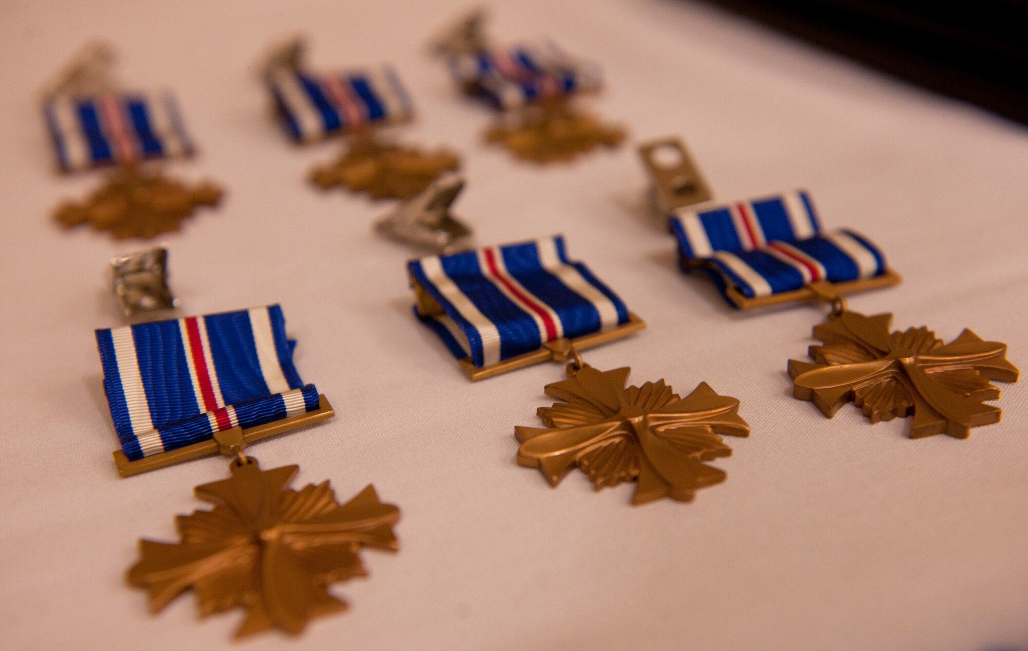 MOODY AIR FORCE BASE, Ga.-- Distinguished Flying Cross Medals to be presented to six members of the 41st Rescue Squadron sit on a table during an award ceremony May 20. The Distinguished Flying Cross is a medal that’s awarded to any officer or enlisted member of the U.S. armed forces who distinguishes himself or herself in support of operations by heroism or extraordinary achievement while participating in an aerial flight. (U.S. Air Force photo/Airman 1st Class Joshua Green)(RELEASED)
