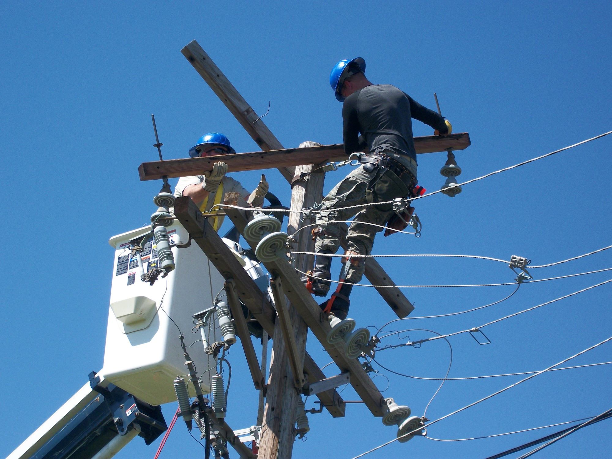 Tech Sgt. Phillip Wilson (left) and Staff Sgt. Austin Hollingshead, both of the 375th Civil Engineer Squadron, repair a power pole at Little Rock Air Force Base, Ark.  A tornado struck Little Rock AFB April 25 and Airmen from Scott responded April 29. (Courtesy photo)