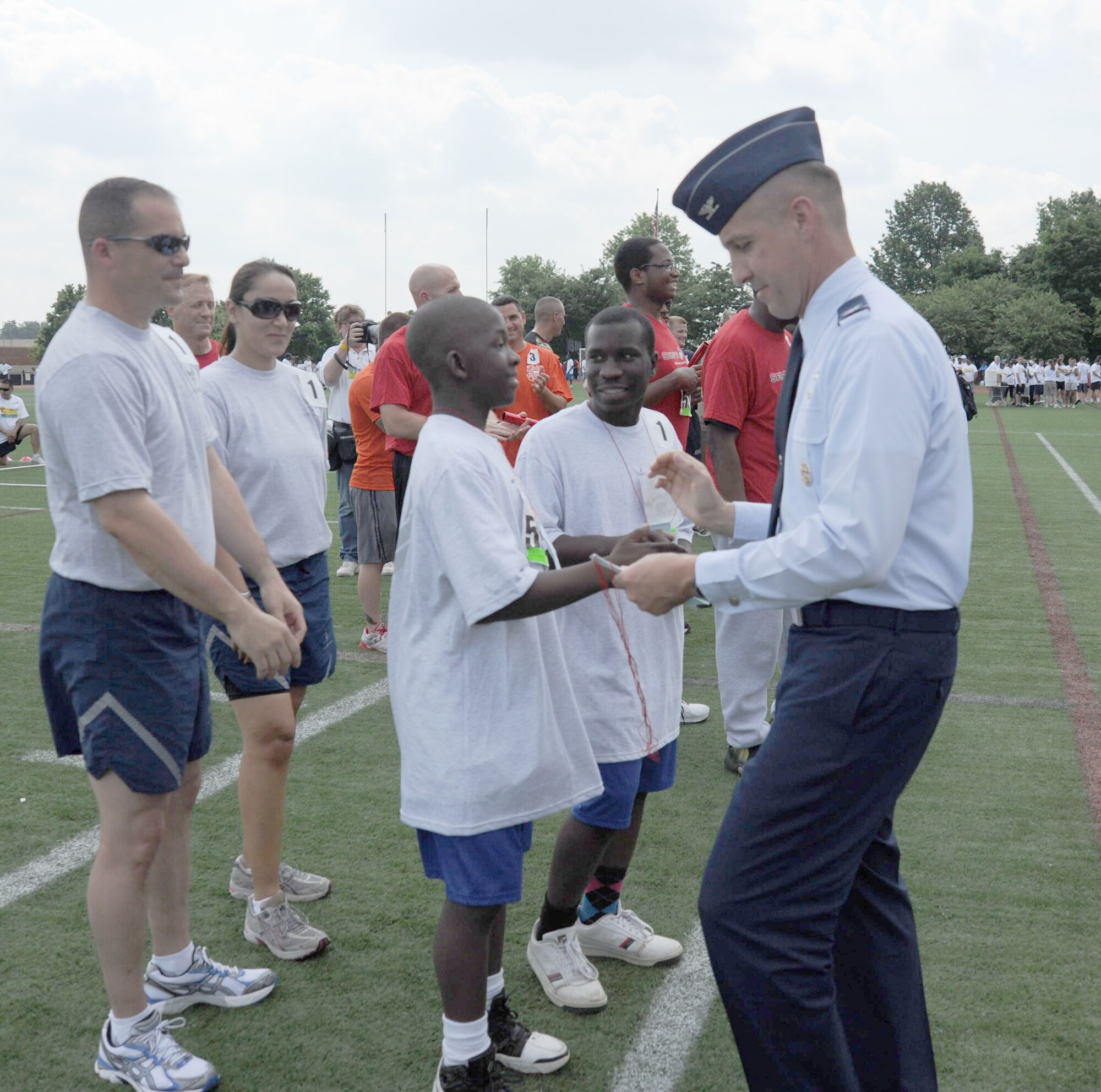 844th Communications Group Commander Col. Anthony Thomas presents ribbons to the unified relay team consisting of AFDW Airmen and Special Olympics athletes during the 2011 D.C. Special Olympics, held May 24-26 at the Catholic University of America’s athletic facility, Washington D.C. Special Olympics competitors were supported by 246 servicemembers representing every branch of the military.
