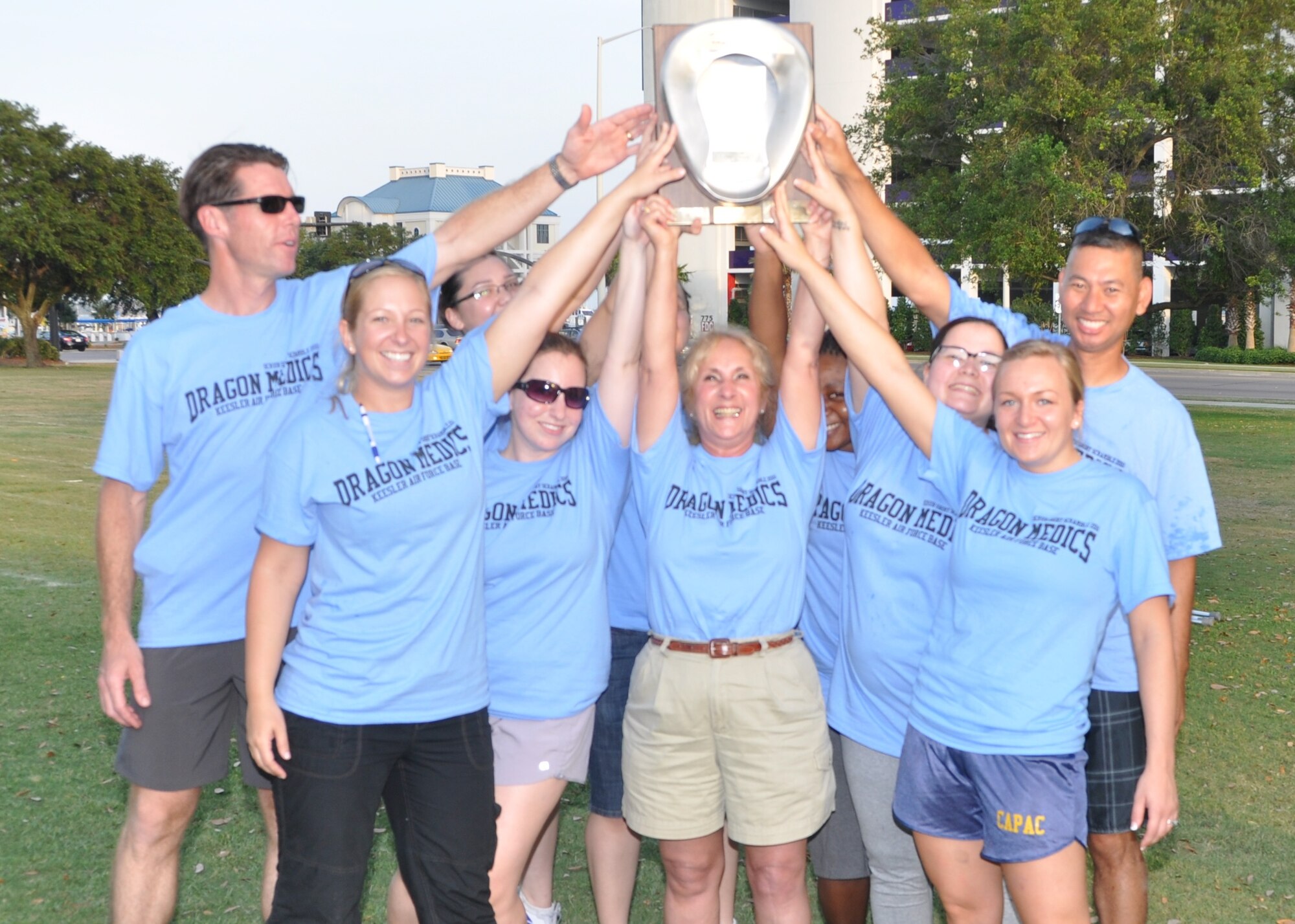Jubilant 81st MDG Hospital team members reach for the “Golden Bedpan Trophy” held by Allison Plunk, center, after learning they had won the annual “Scrub Shirt Scramble” May 12 at the Biloxi Town Green. Other “Dragon Medics” are, from left, William Moore, Mary Peterson, Amy Lynn, Marjorie Honesto and Jennifer Chilson. Others are, partially hidden, Jenai Bielinski, Kaline Marques and Tanaessa Smith and Nelson Viniegra, right.  (U.S. Air Force photo by Steve Pivnick)