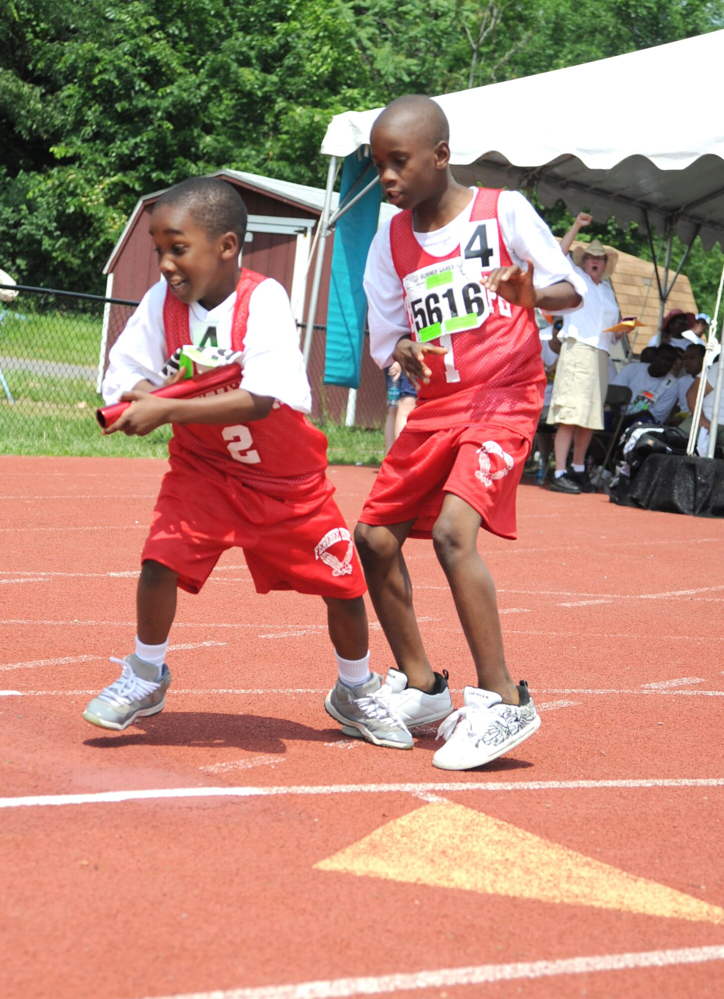 Six-Year-Old Teon Jackson of Ferebee Hope Elementary School in Washington, D.C. accepts a relay baton from his classmate during the 2011 D.C. Special Olympics,  held May 24-26 at the Catholic University of America’s athletic facility, Washington D.C. Special Olympics competitors were supported by 246 servicemembers representing every branch of the military.