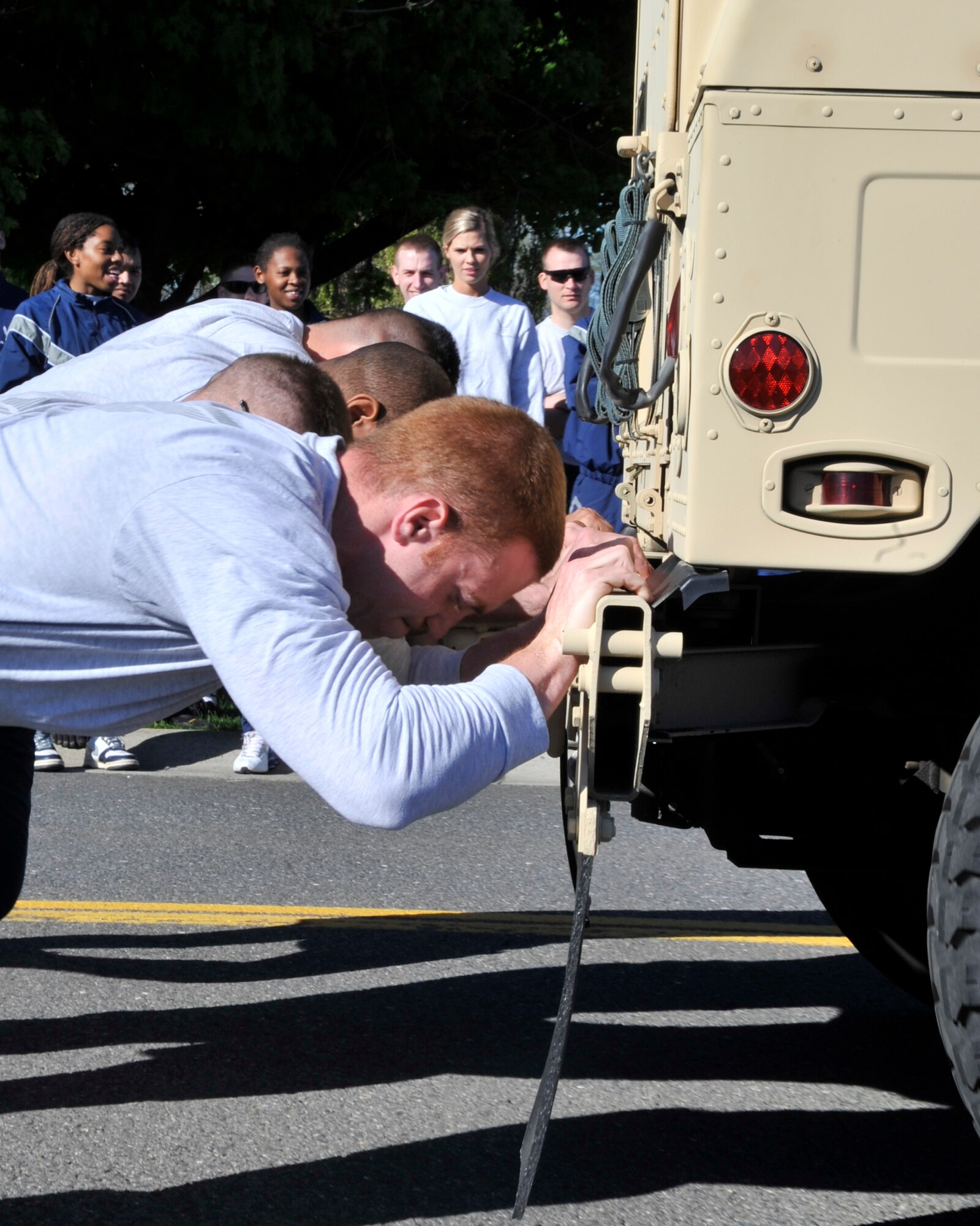 Senior Airman Ralph Debiase, 92 Medical Operation Squadron medical technician, along with fellow teammates also from the 92nd MDOS, competes in the Humvee push during the Commander’s 101 Critical Days of Summer Challenge. (U.S. Air Force photo/Airman 1st Class Mary O’Dell)