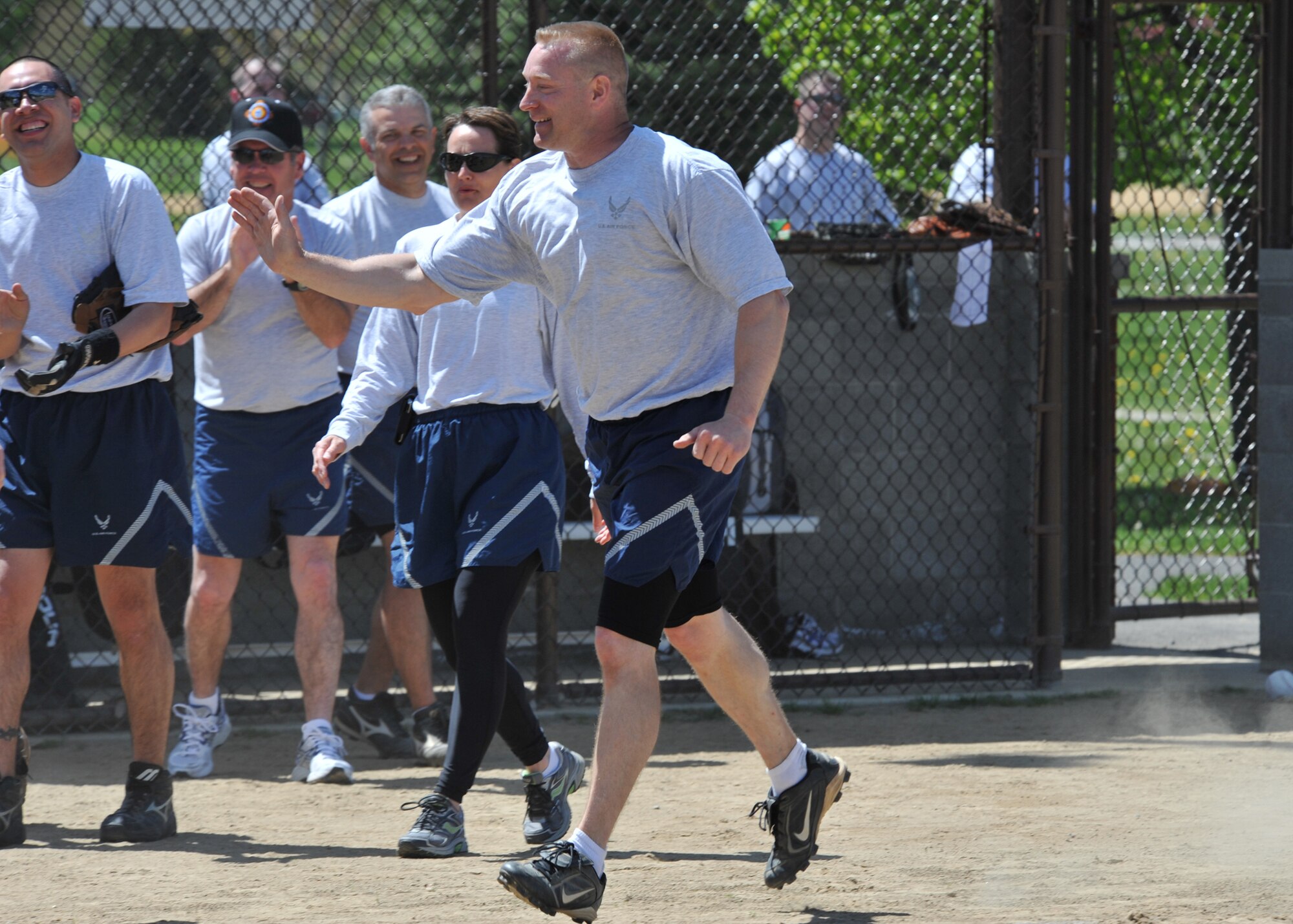 Master Sgt. Timothy Vanhorn, 92nd Civil Engineer Squadron first sergeant is congratulated by his teammates, May 20, 2011, after getting a homerun during the chief’s and first sergeant’s versus commanders at Fairchild Air Force base. The chief’s and first sergeant’s team won advancing them to the championship game against the enlisted team. (U.S. Air Force photo by Staff Sgt. Michael Means)