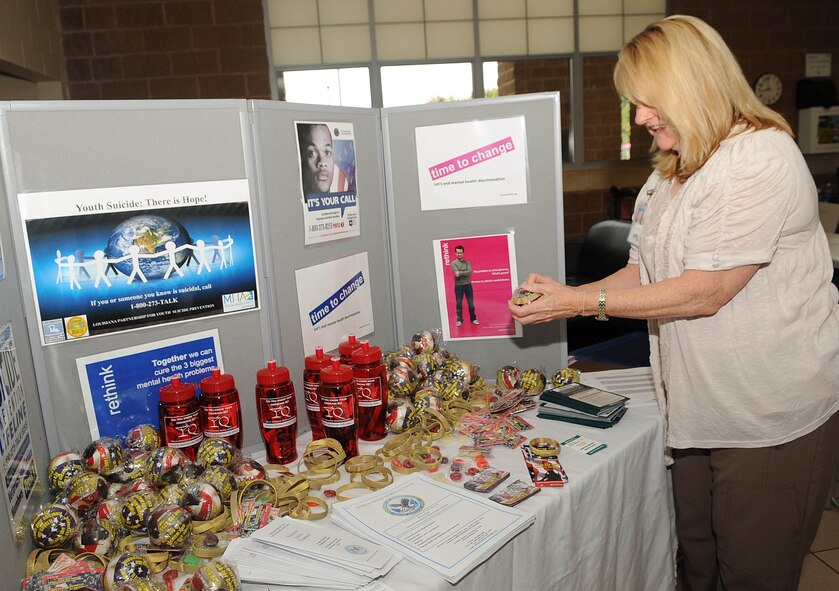 Tia McKoin, from Overton Brooks Veterans Hospital, sets up a display for suicide prevention during the 2nd Bomb Wing Sports Day on Barksdale Air Force Base, La., May 24. Sports Day is comprised of various competitive athletic events to help promote physical fitness and information booths concerning health and wellness. (U.S. Air Force photo/Senior Airman Kristin High)(RELEASED) 
