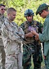 Maj. Jeff Schmidt, team leader, discusses a passport found on a prisoner with “simulated” partner-nation special forces soldiers during the Combat Aviation Advisor course’s Raven Claw exercise May 24 at Duke Field, Fla. As part of the exercise, 19 CAA students deployed to a foreign nation to advise and train their air forces in fixed wing and rotary aircraft operations.  The four-day exercise is the capstone of 12 weeks of baseline certification training for CAA.  The year-long process to become a CAA also includes months of language and flight training.  (U.S. Air Force photo/Tech. Sgt. Samuel King Jr.)