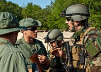 Capt. Robert Rennell, team intelligence officer, discusses an incident with “simulated” partner-nation special forces soldiers during the Combat Aviation Advisor course’s Raven Claw exercise May 24 at Duke Field, Fla.  As part of the exercise, 19 CAA students deployed to a foreign nation to advise and train their air forces in fixed wing and rotary aircraft operations.  The four-day exercise is the capstone of 12 weeks of baseline certification training for CAA.  The year-long process to become a CAA also includes months of language and flight training.  (U.S. Air Force photo/Tech. Sgt. Samuel King Jr.)