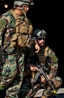 Maj. Jeff Schmidt, team leader, and Capt. Robert Rennell, intelligence officer, react to the sound of a firefight west of their camp during the Combat Aviation Advisor course’s Raven Claw exercise May 24 at Duke Field, Fla.  As part of the exercise, 19 CAA students deployed to a foreign nation to advise and train their air forces in fixed wing and rotary aircraft operations.  The four-day exercise is the capstone of 12 weeks of baseline certification training for CAA.  The year-long process to become a CAA also includes months of language and flight training.  (U.S. Air Force photo/Tech. Sgt. Samuel King Jr.)
