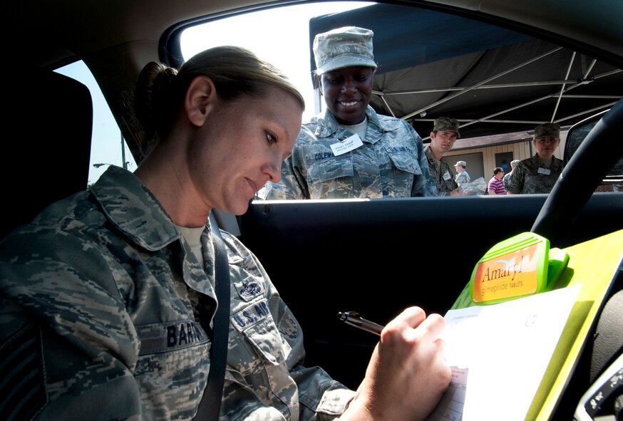 MOODY AIR FORCE BASE, Ga.-- Tech. Sgt. Rebecca Barton, 23rd Wing ground safety, fills out paperwork  for Staff Sgt. Terri Coleman, 23rd Medical Group health and wellness center, as she travels through the point of distribution line May 25. The 23rd MDG tested their ability to process thousands of individuals in a short time. (U.S. Air Force photo/Airman 1st Class Benjamin Wiseman)(RELEASED)