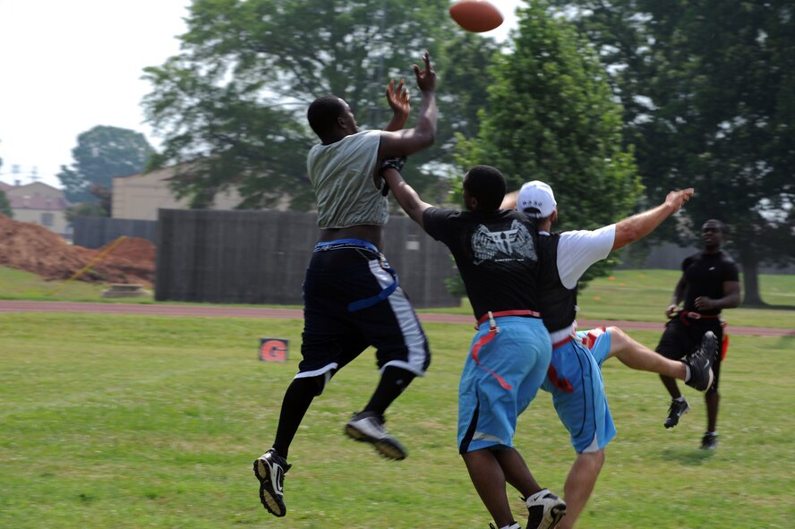 An Airman from the 2nd Operations Support Squadron jumps over Airmen from the 2nd Civil Engineer Squadron to catch a football during the 2nd Bomb Wing Sports Day football tournament on Barksdale Air Force Base, La., May 25. Sports Day is comprised of various competitive athletic events to help promote physical fitness. (U.S. Air Force photo/Airman 1st Class Micaiah Anthony) (RELEASED)