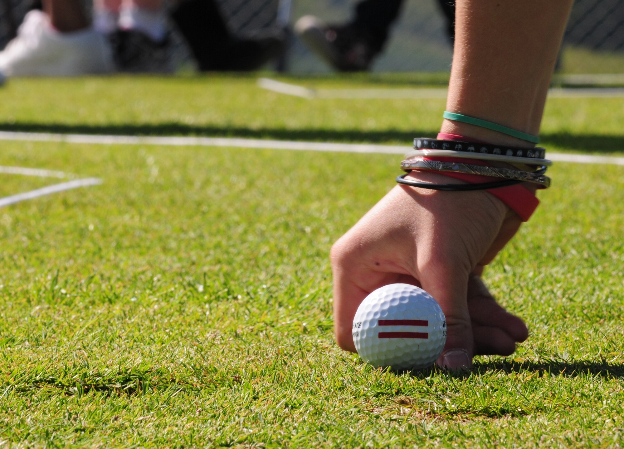 A child places a ball marker on the green while participating in the youth golf clinic at the Eifel Mountain Golf Course here May 23. The clinic was taught by Tee it Up Inc. and sponsored by the 52nd Force Support Squadron to teach the youth how to play the sport. (U.S. Air Force photo/Airman 1st Class Matthew Fredericks)