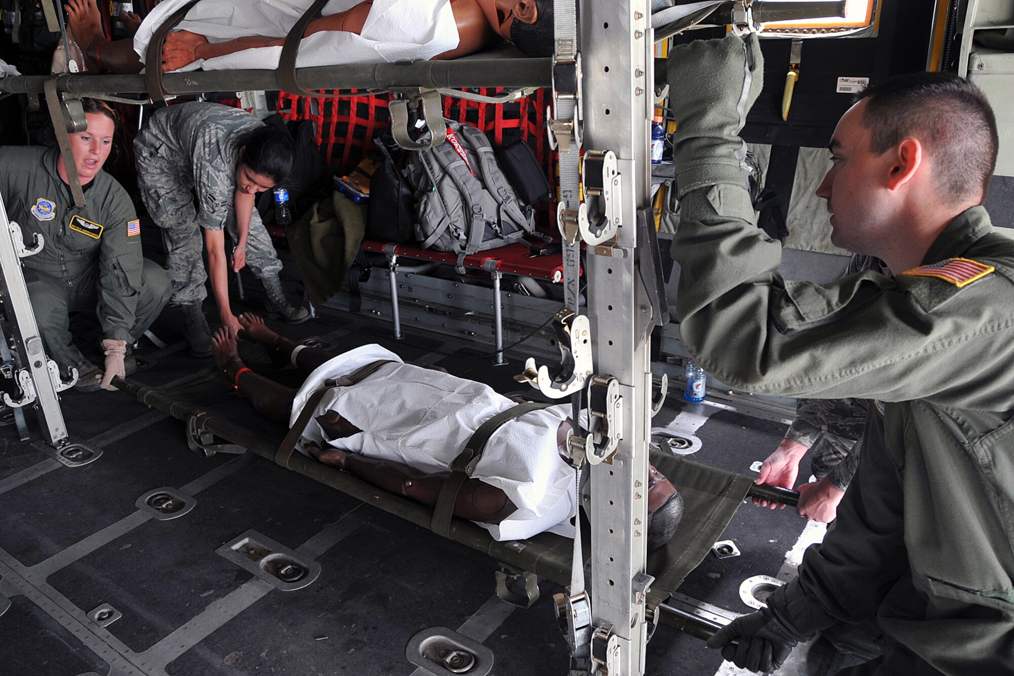 OFFUTT AIR FORCE BASE, Neb. --Members of the 55th MDS, carefully place simulated victims in the aircraft. Offutt Afb performed a national level exercise for 2011 on May 19 at the field house. Many participants were on hand for the NDMS Exercise, including many base agencies from Omaha simulating real life transporting of medical personel and victims acting out and responding giving medical care in case of a community emergency. U.S. Air Force Photo by Jeff W. Gates.