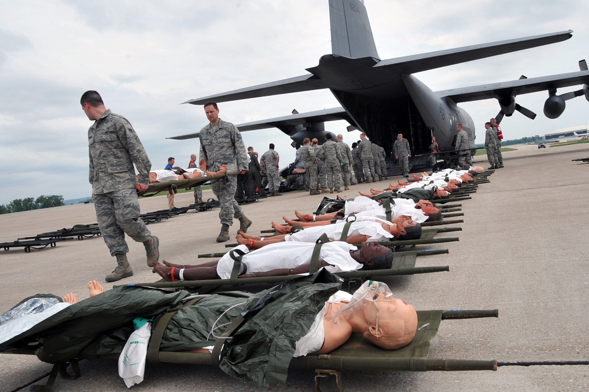 OFFUTT AIR FORCE BASE, Neb. --Members of the 55th MDG transport simulated victims from the aircraft. Offutt Afb performed a national level exercise for 2011 on May 19 at the field house. Many participants were on hand for the NDMS Exercise, including many base agencies from Omaha simulating real life transporting of medical personel and victims acting out and responding giving medical care in case of a community emergency. U.S. Air Force Photo by Jeff W. Gates.