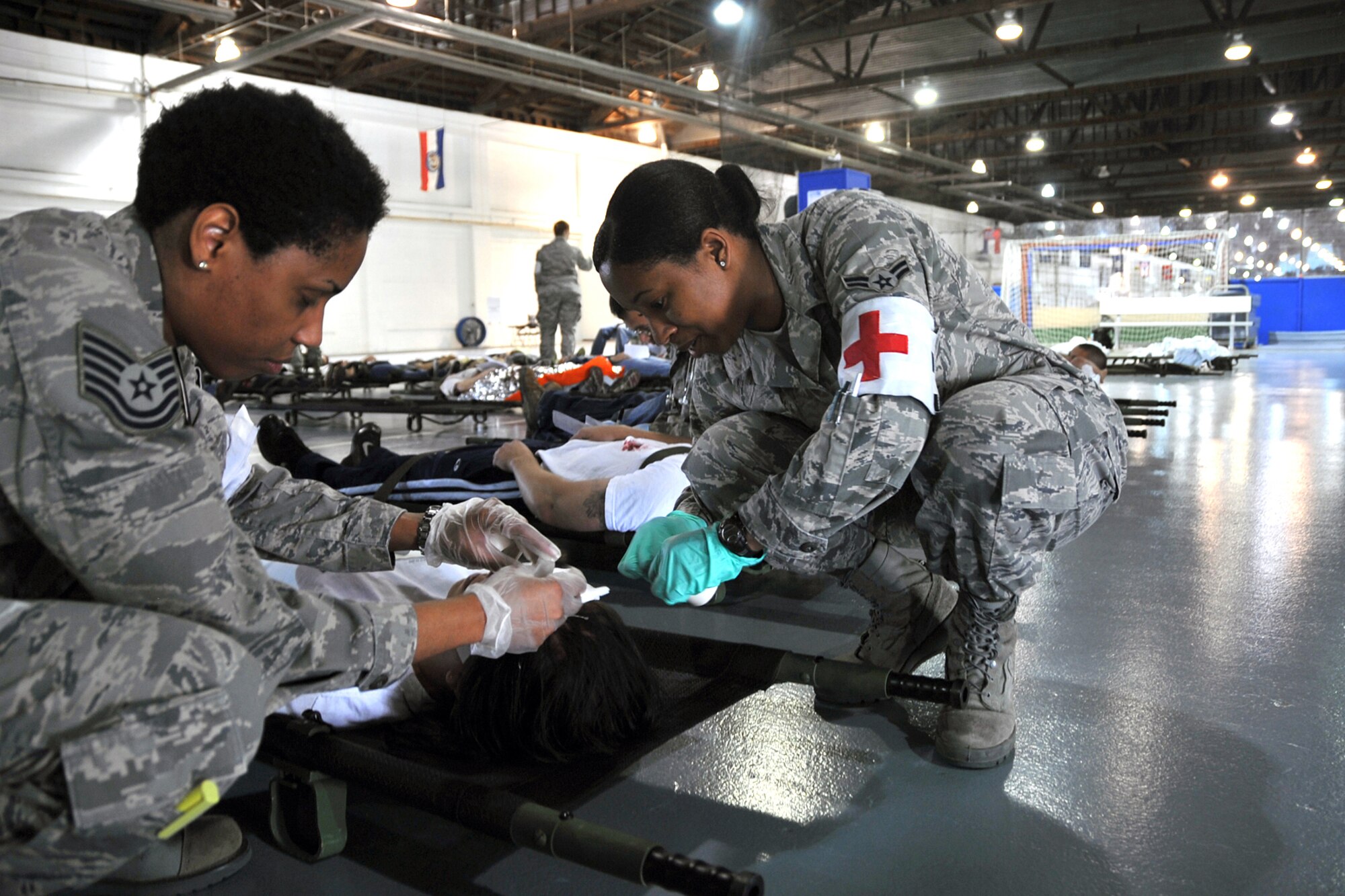 OFFUTT AIR FORCE BASE, Neb. --TSgt Angela Marsh and A1C Marqualla Sanders from the 55th MDOS, perform medical response duties for a simulated victim. Many participants were on hand for the NDMS Exercise, including many base agencies from Omaha simulating real life transporting of medical personel and victims acting out and responding giving medical care in case of a community emergency. U.S. Air Force Photo by Jeff W. Gates. 