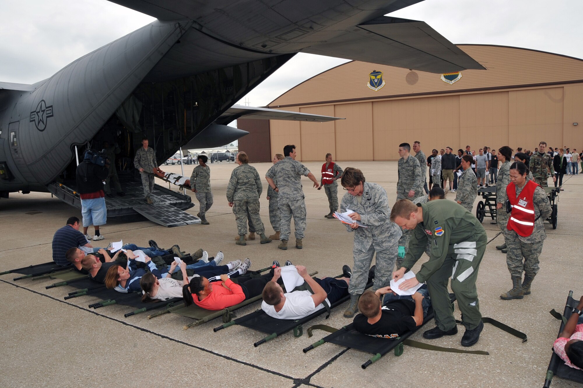 OFFUTT AIR FORCE BASE, Neb. --MDG personel hand copies of Aeromedical patient records to the patients as they lay on the tarmac for transport inside. These are tracking sheets from point of embarkation to point of debarkation like transportable medical records and anything that happened in flight is added. Offutt Afb performed a national level exercise for 2011 on May 19 at the field house. Many participants were on hand for the NDMS Exercise, including many base agencies from Omaha simulating real life transporting of medical personel and victims acting out and responding giving medical care in case of a community emergency. U.S. Air Force Photo by Jeff W. Gates. 