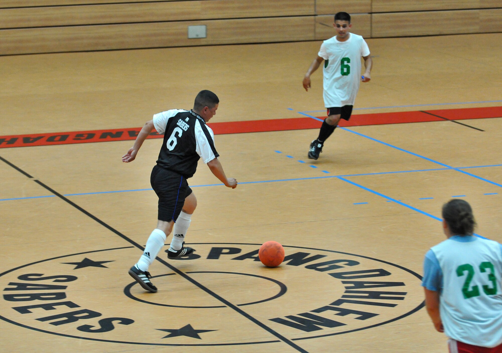 SPANGDAHLEM AIR BASE, Germany – Ramon Munoznuno, 52nd Force Support Squadron Sabers, drives the ball up court as number six Jose Serrano and Tiffany Caramella, from the 52nd Civil Engineer Squadron Force, defend their goal during the 52nd Fighter Wing’s intramural indoor soccer championship game at the Skelton Memorial Fitness Center May 20. The Force defeated the Sabers 9-3 to win the championship. (U.S. Air Force photo/Senior Airman Nick Wilson)