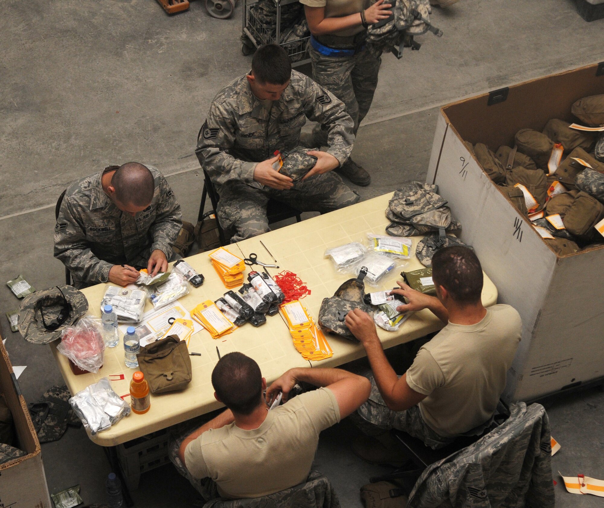 Members from the 379th Air Expeditionary Wing pack Individual First Aid Kit's May 26 in Southwest Asia. The IFAK packing gathers many Airmen and is done all voluntarily.(U.S. Air Force photo/ Staff Sgt. Anthony Graham)