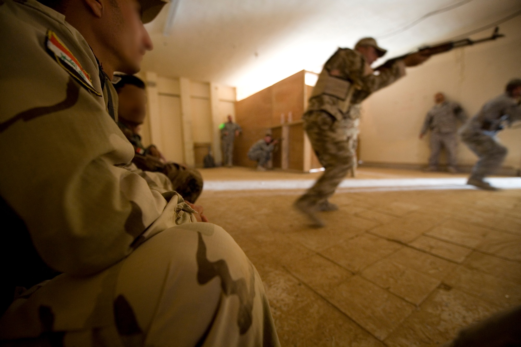 SATHER AIR BASE, Iraq -- Iraqi security forces members storm a room during advanced security forces training May 23. The Iraqi servicemembers were undergoing this training as a precursor to personal security detail training. (U.S. Air Force illustration by Staff Sgt. Levi Riendeau)
