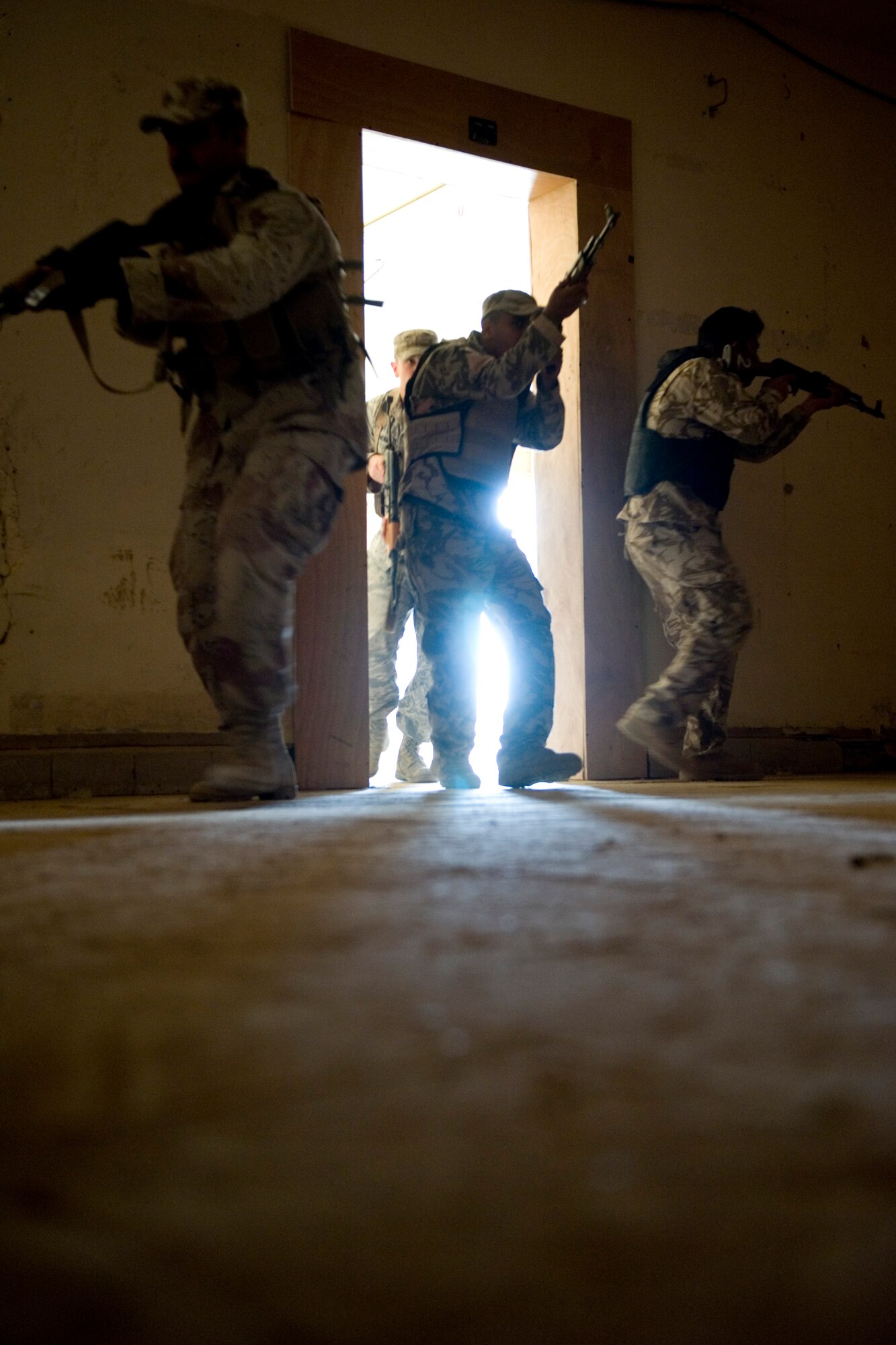 SATHER AIR BASE, Iraq -- Iraqi security forces members storm a room during advanced security forces training May 23. U.S. Air Force trainers with the 447th Expeditionary Security Forces Squadron are teaching Iraqi servicemembers advanced security forces tactics to prepare them for personal security detail training. (U.S. Air Force photo by Staff Sgt. Levi Riendeau)