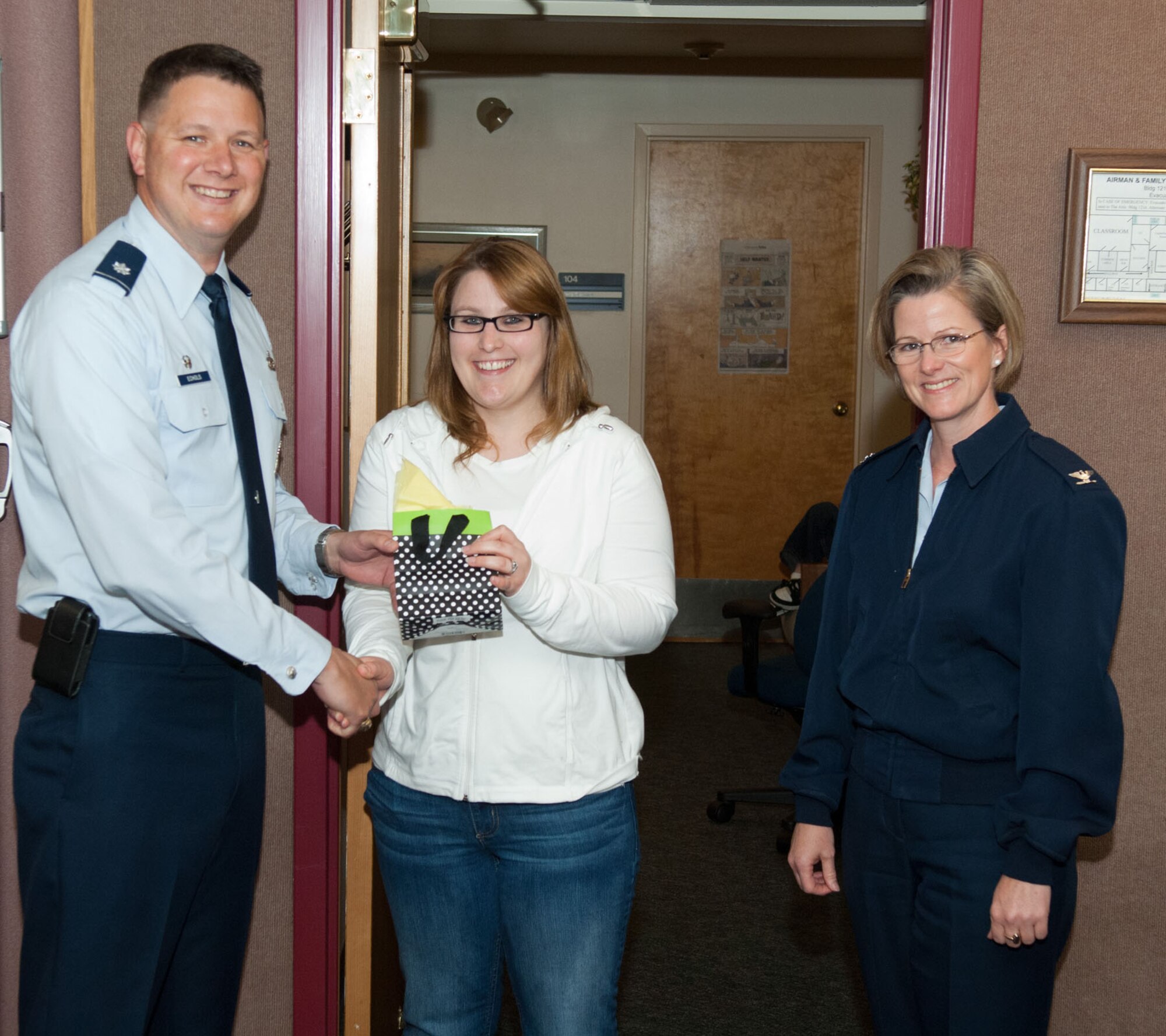 HANSCOM AIR FORCE BASE, Mass. – Lt. Col. Chris Echols (left), 66th Security Forces Squadron commander, along with Col. Stacy L. Yike, 66th Air Base Group commander, present Savannah Hewett with a gift during a Key Spouse meeting May 16. Ms. Hewett won the Air Force Materiel Command Key Spouse of the Year award for her creative initiatives to communicate with spouses of deployed Airmen in the 66th Security Forces Squadron. (U.S. Air Force photo by Rick Berry)