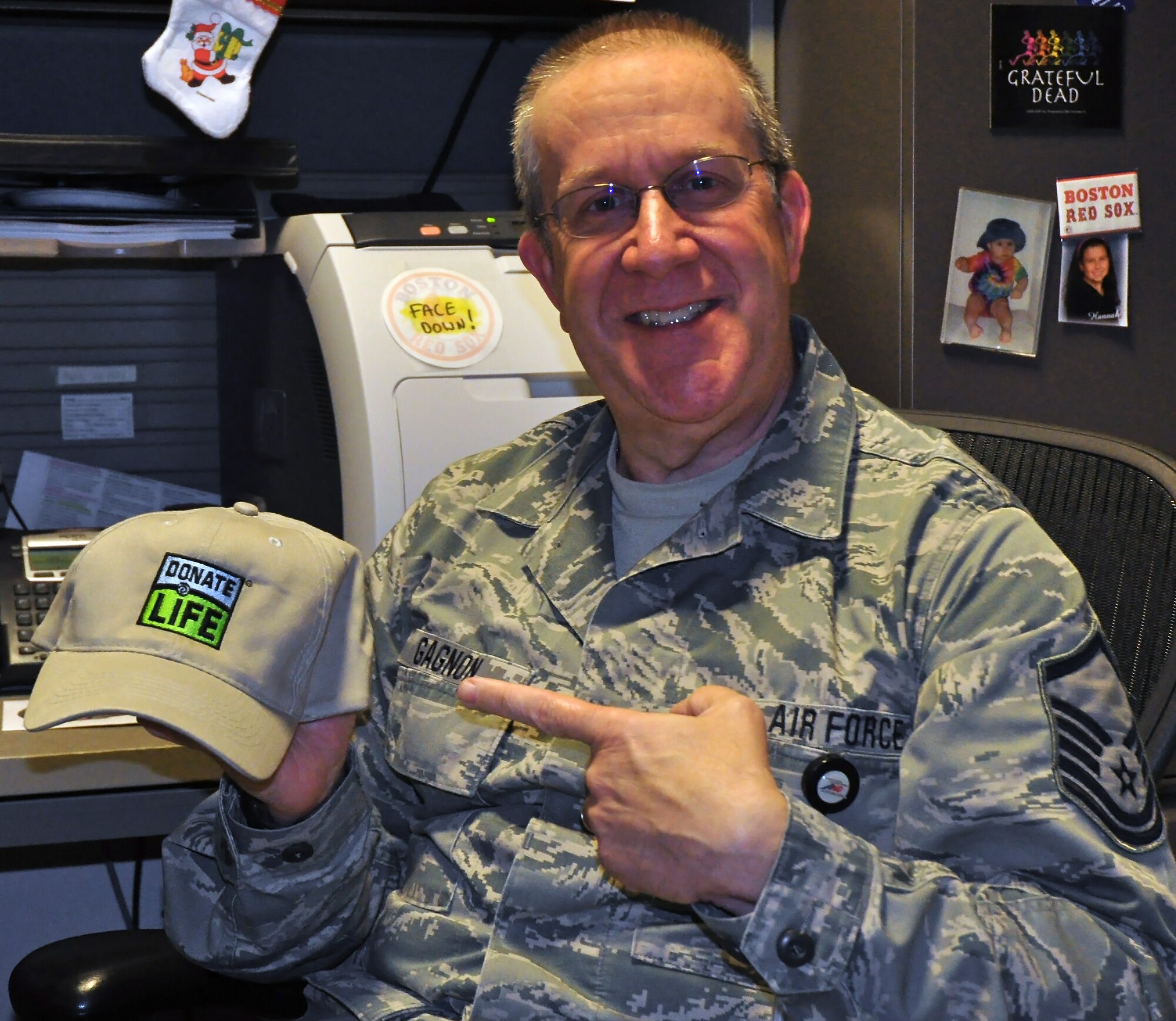 Master Sgt. Marc Gagnon poses with his "Donate Life" baseball cap days before he donates his kidney to an anonymous recipient. His donation sparks a series of three other kindey donations through a process called a kidney chain transplant.