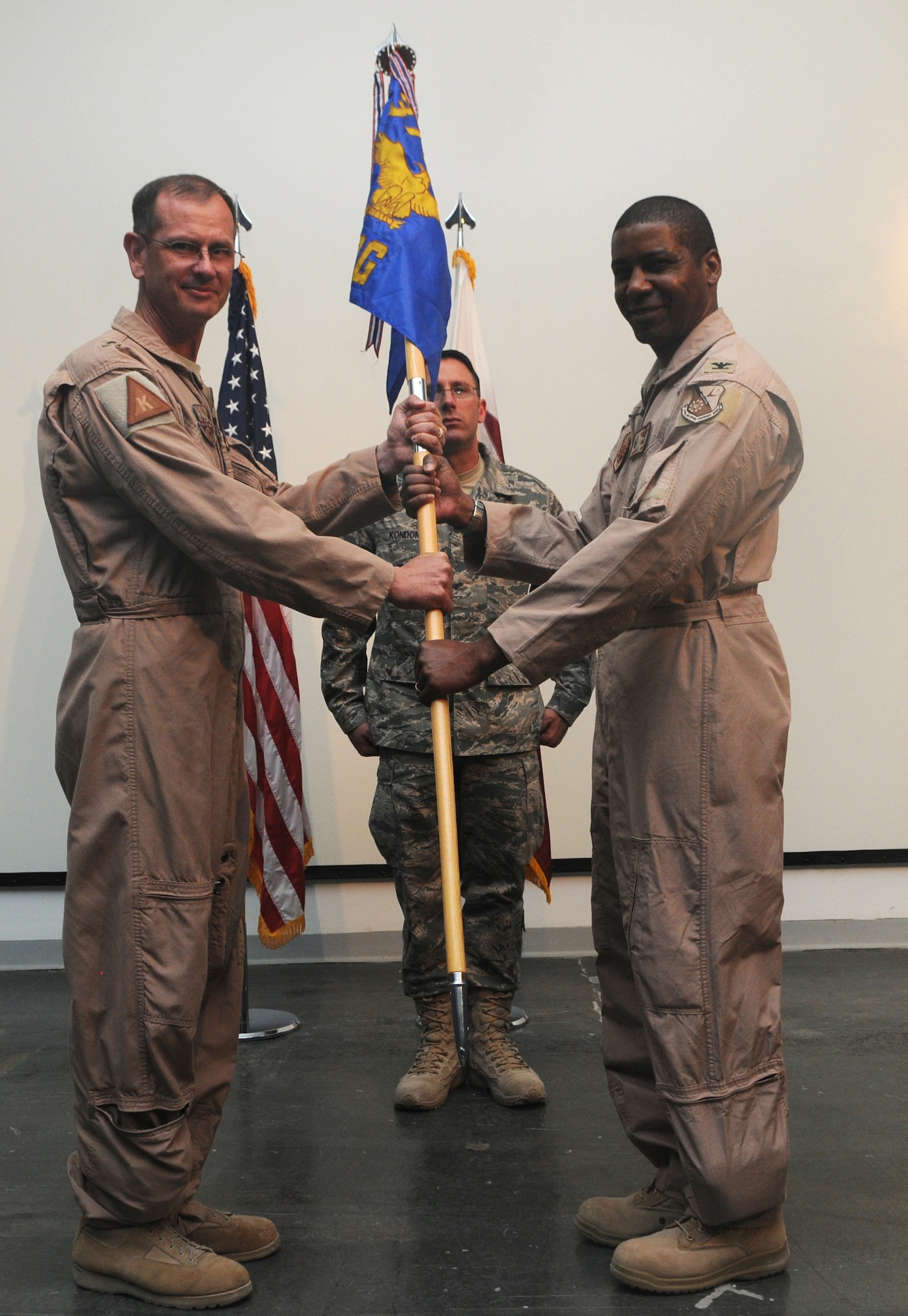 Brig. Gen. Randy Kee, 379th Air Expeditionary Wing commander, passes the 379th Expeditionary Operations Group guidon to the new commander, Col. Randall Reed, in a change of command ceremony May 25 in Southwest Asia. Colonel Reed assumed command of the 379th EOG from Col. Christopher Kulas.  The 379th EOG conducts aerial and air fueled operations and support for U.S. and coalition forces in the U.S. Air Forces Central area of responsibility.  (U.S. Air Force photo/Staff Sgt. Anthony Graham)  