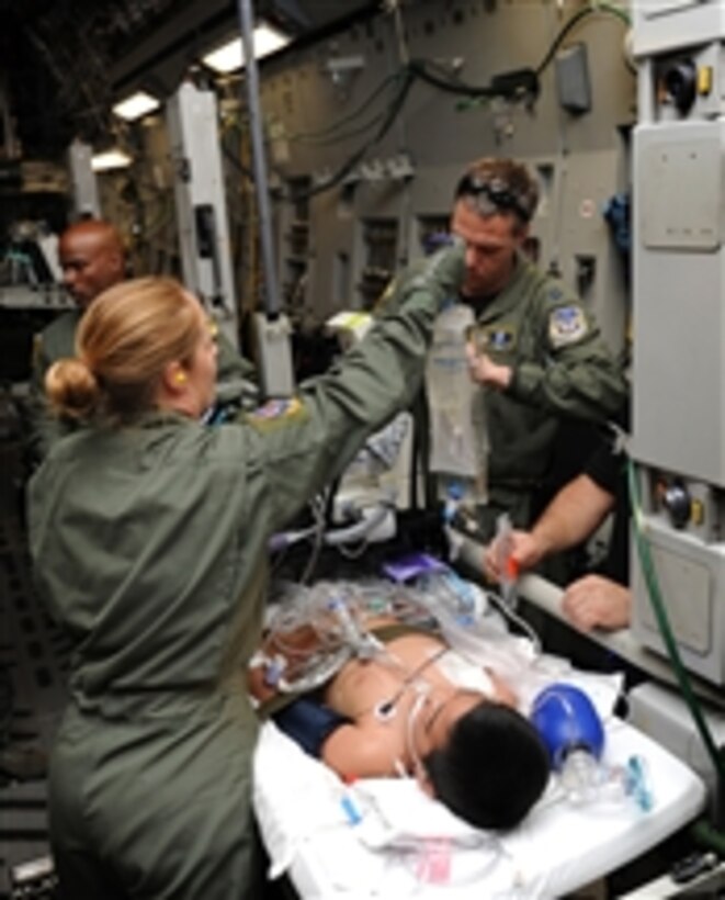 Master Sgt. Molly Quentin and Capt. John-Michael Fowler care for a critically ill patient on a medical evacuation mission from Pago Pago, American Samoa, to Tripler Army Medical Center, Hawaii, on May 22, 2011.  Quentin is an aeromedical evacuation technician assigned to the 18th Aeromedical Evacuation Squadron Det. 1.  Fowler is a critical care air transport nurse with the 13th Air Force surgeon general's office.  