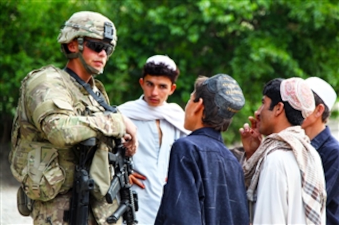 U.S. Army Spc. Eric Frazier, with 2nd Platoon, Charlie Company, 1st Battalion, 26th Infantry Regiment, 3rd Brigade, 1st Infantry Division, speaks to children in Spera district of Khowst province, Afghanistan, on May 14, 2011.  