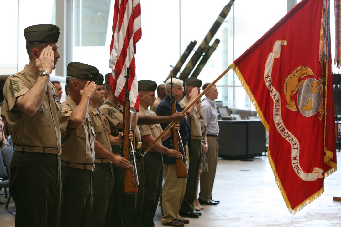 Attendees of the 4th Marine Aircraft Wing Sergeant Major relief and appointment ceremony salute the colors as the national anthem is played at the World War II Museum, May 26.  Sgt. Maj. Courtney Curtis took over for Sgt. Maj. Paul Anderson as the 4th MAW Sergeant Major.